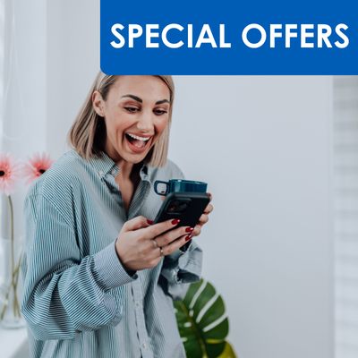 lady smiling looking at phone and drinking coffee