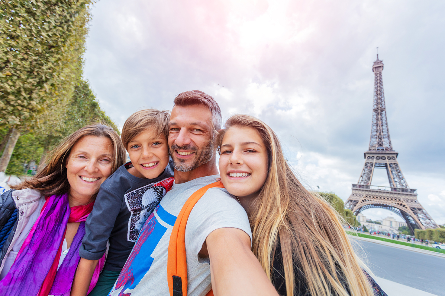 A family in front of the Eifel Tower smiling thinking they saved the money for the trip in a Telcoe Club Account.